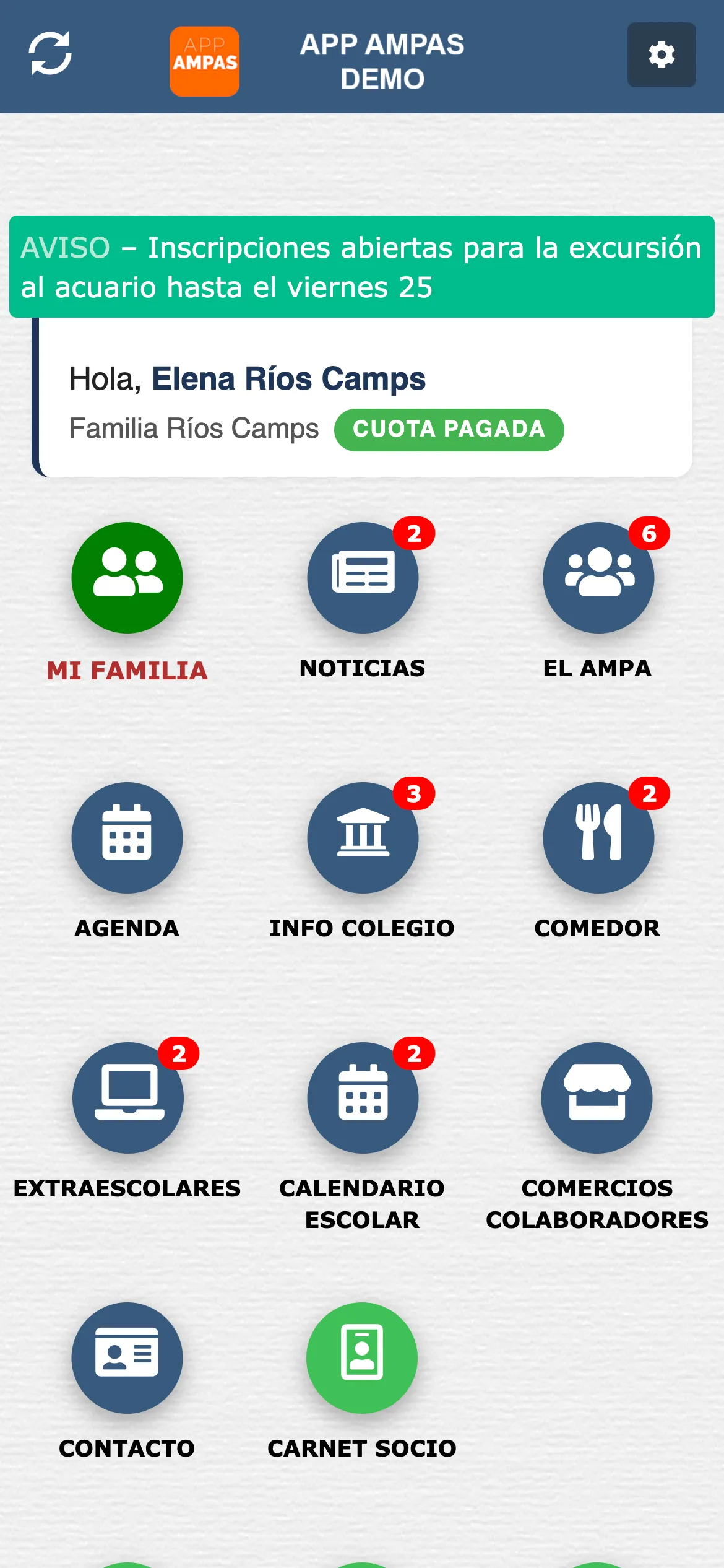 Portada de la App del AMPA en un móvil: arriba, una banda verde de aviso con las inscripciones abiertas para la excursión al acuario; debajo, el saludo a la familia con la etiqueta de cuota pagada; y después la rejilla de iconos redondos: Mi familia, Noticias, El AMPA, Agenda, Info colegio, Comedor, Extraescolares, Calendario escolar, Comercios colaboradores, Contacto y Carné de socio.